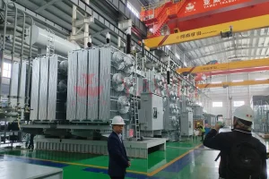 International client visiting Yawei transformer factory for in-depth inspection of a 110kV/33kV 40MVA power transformer during manufacturing and testing